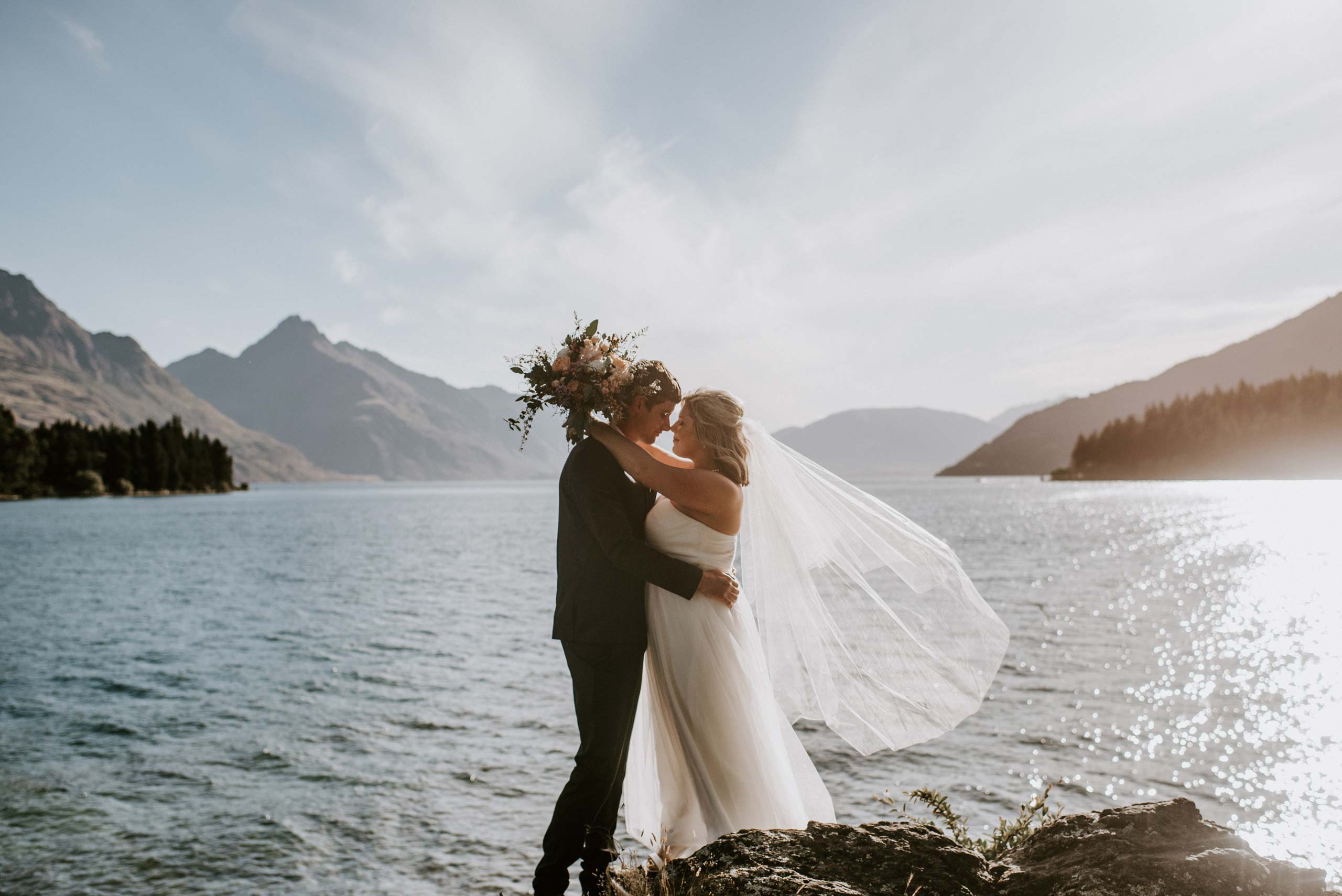 Wedding couple embracing by the lake - Queenstown Wedding Packages